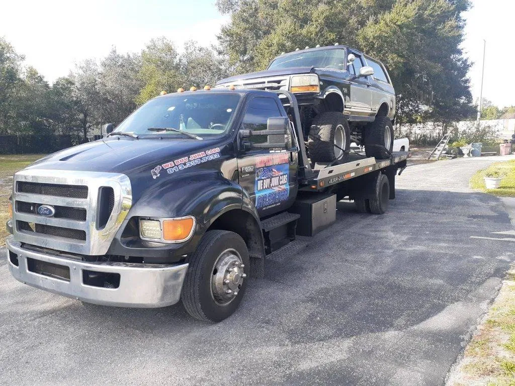 Empire Towing Ford F-650 parked with a dark Bronco loaded in a driveway